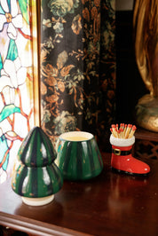 Balsam Fir tree candle with lid off beside a Santa boot match holder