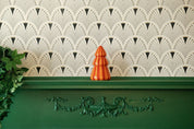 Red and coral striped ceramic tree candle on a mantel