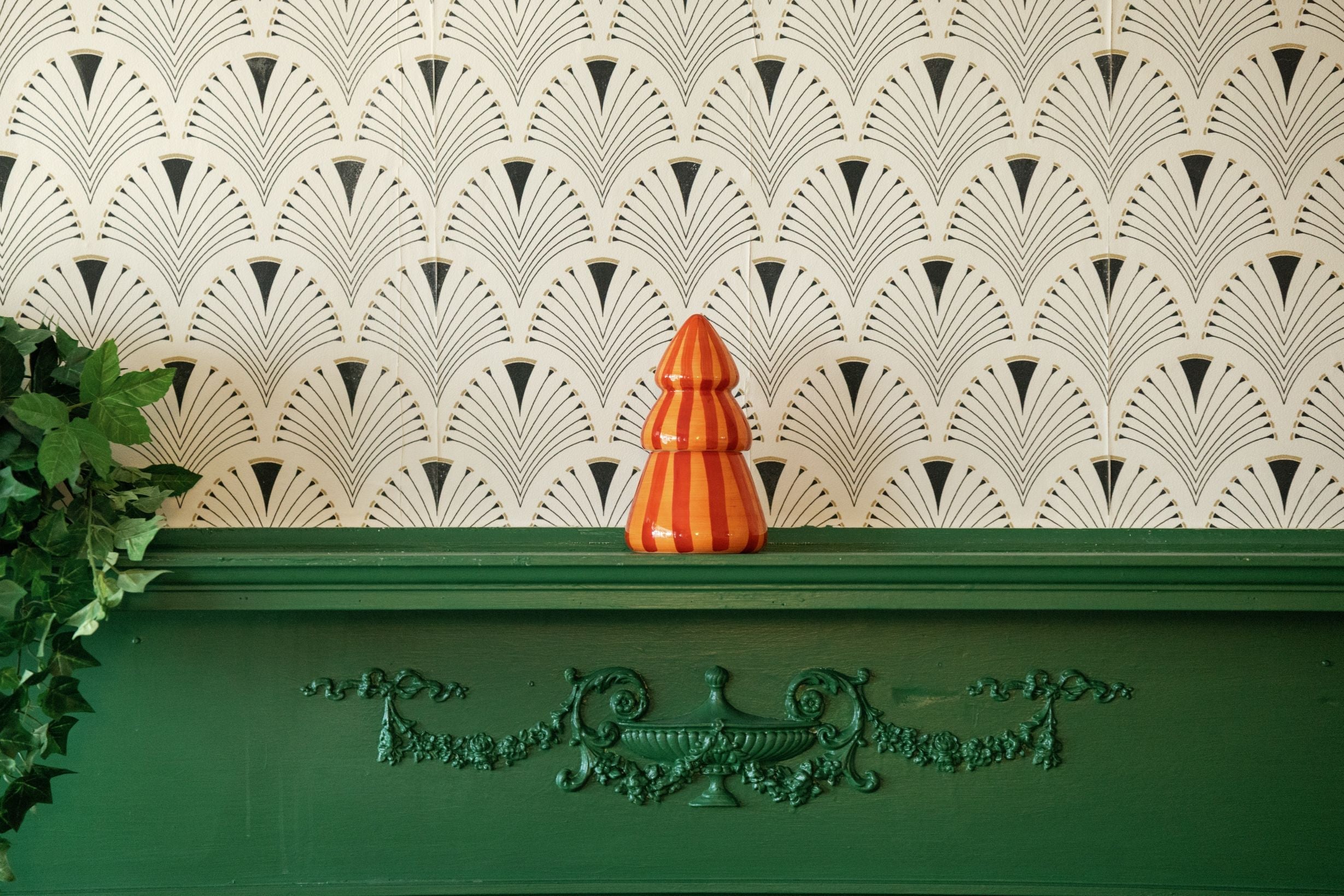 Red and coral striped ceramic tree candle on a mantel